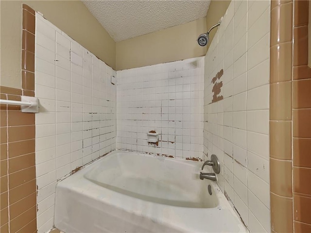 bathroom featuring tiled shower / bath, a textured ceiling, and tile walls