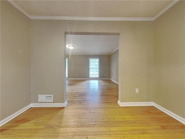 unfurnished room featuring ornamental molding and light hardwood / wood-style flooring