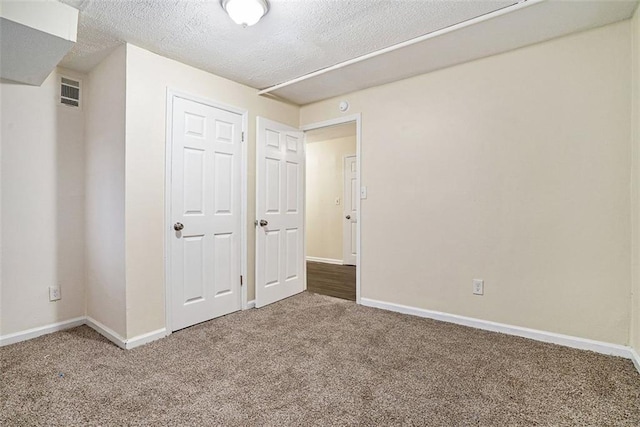 unfurnished bedroom featuring carpet floors and a textured ceiling