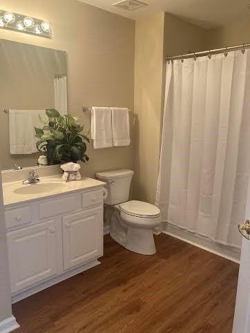 bathroom featuring vanity, hardwood / wood-style flooring, a shower with curtain, and toilet