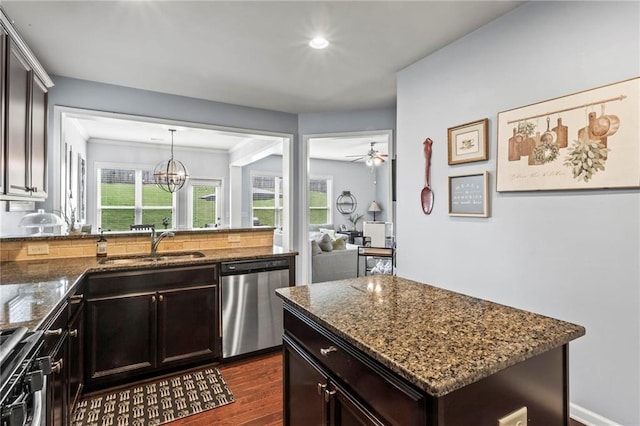 kitchen with dark stone countertops, a sink, dishwasher, dark wood finished floors, and stove