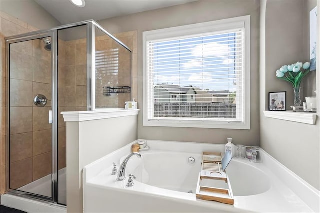 full bath featuring a shower stall, plenty of natural light, and a garden tub