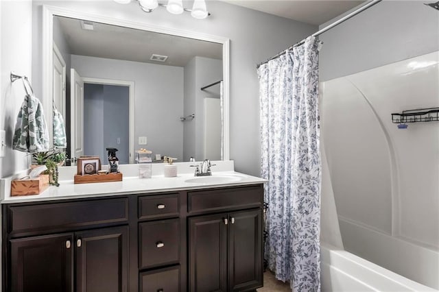 bathroom with shower / bath combo with shower curtain, a sink, visible vents, and double vanity