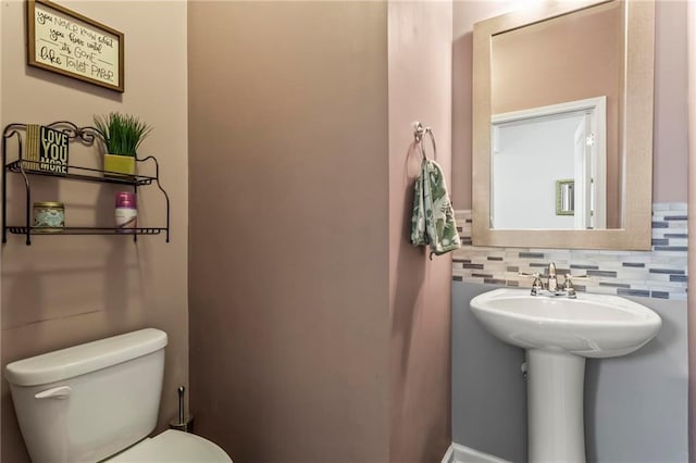 bathroom featuring decorative backsplash, a sink, and toilet