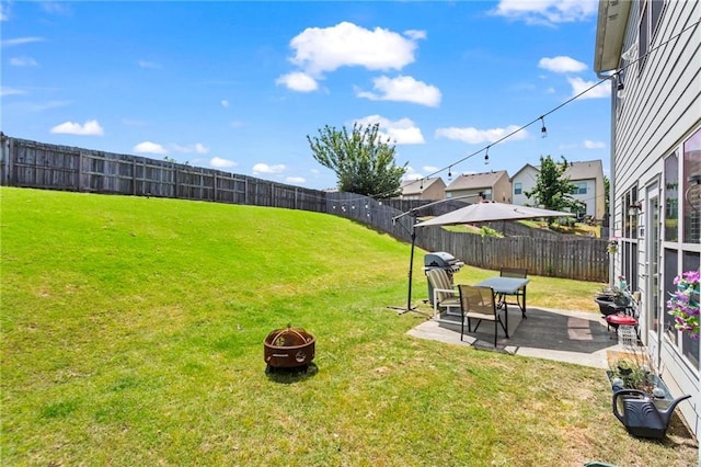 view of yard with a fenced backyard, a patio area, and an outdoor fire pit