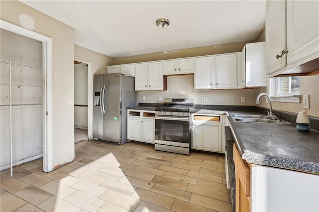 kitchen with appliances with stainless steel finishes, sink, and white cabinets