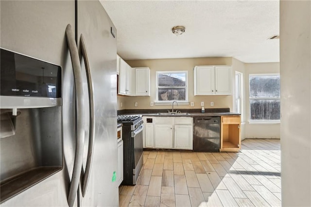 kitchen with appliances with stainless steel finishes, sink, and white cabinets