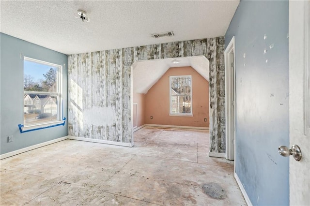 bonus room featuring vaulted ceiling and a textured ceiling