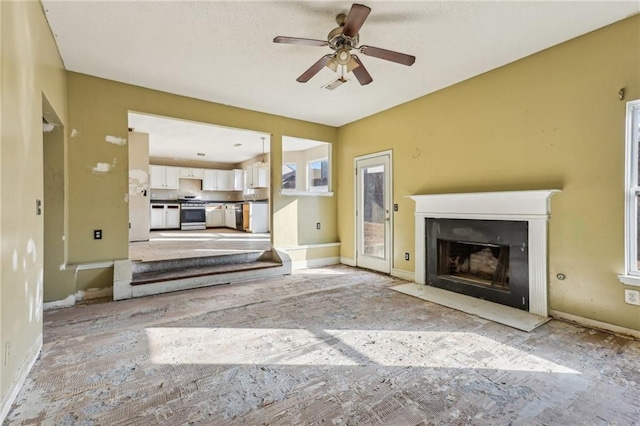 unfurnished living room with ceiling fan