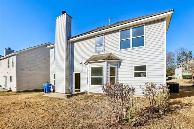 rear view of house with a yard and central AC