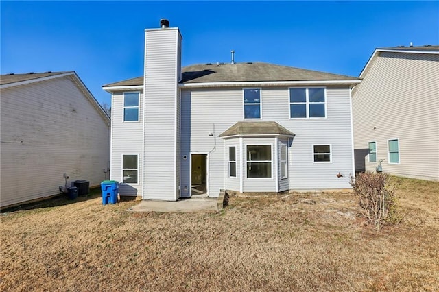 rear view of property featuring central AC, a patio area, and a lawn