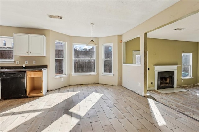 kitchen featuring a healthy amount of sunlight, white cabinets, decorative light fixtures, and dishwasher