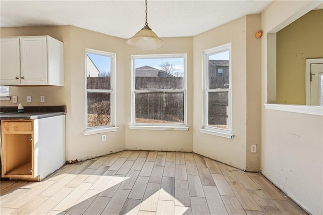 unfurnished dining area featuring light wood-type flooring