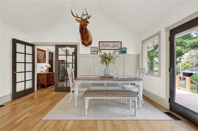 dining room featuring wood ceiling, lofted ceiling, light hardwood / wood-style flooring, and french doors