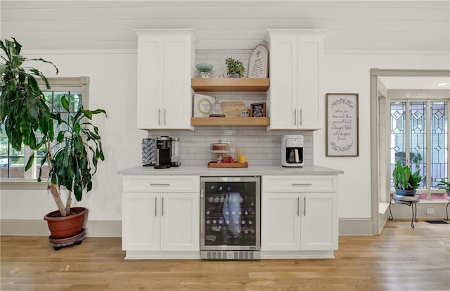 bar featuring white cabinetry, wine cooler, and a wealth of natural light