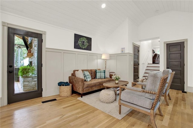 living room featuring vaulted ceiling, light hardwood / wood-style floors, and wooden ceiling