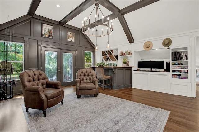 sitting room with lofted ceiling with beams, hardwood / wood-style flooring, an inviting chandelier, and french doors