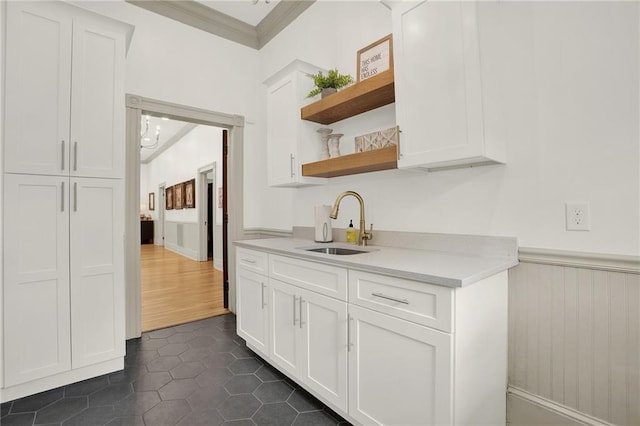 bar with white cabinets, sink, dark wood-type flooring, and crown molding