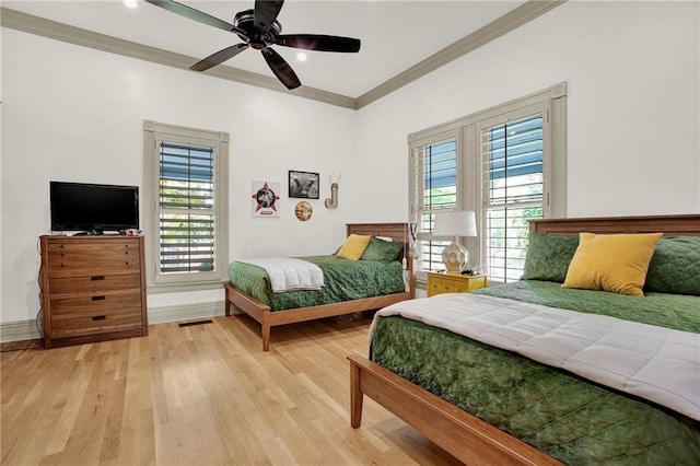 bedroom with ornamental molding, ceiling fan, and light hardwood / wood-style flooring