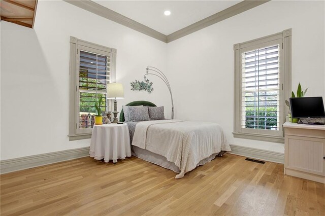 bedroom featuring crown molding and light hardwood / wood-style floors