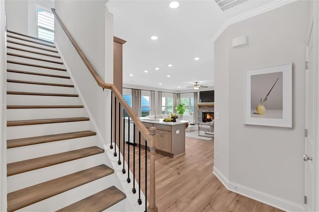 475 Azalea Xing, Dallas, GA 30132 - stairway featuring a lit fireplace, recessed lighting, a ceiling fan, visible vents, and wood finished floors