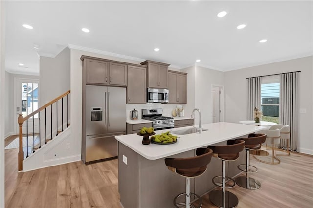 475 Azalea Xing, Dallas, GA 30132 - kitchen with a sink, light wood-type flooring, a center island with sink, a breakfast bar area, and stainless steel appliances