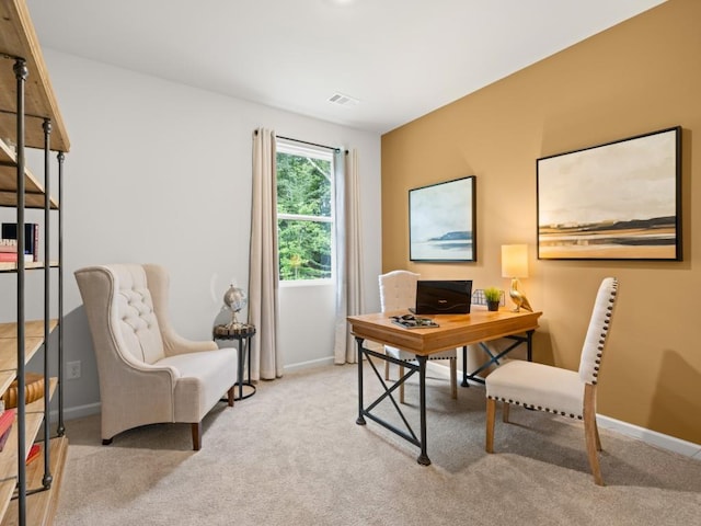 office area featuring baseboards, visible vents, and light colored carpet