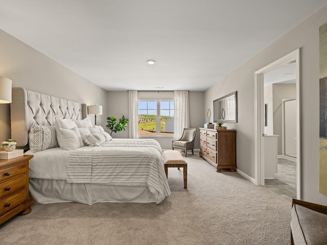 bedroom with baseboards and light colored carpet