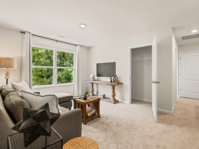 living room with recessed lighting, light colored carpet, visible vents, and baseboards