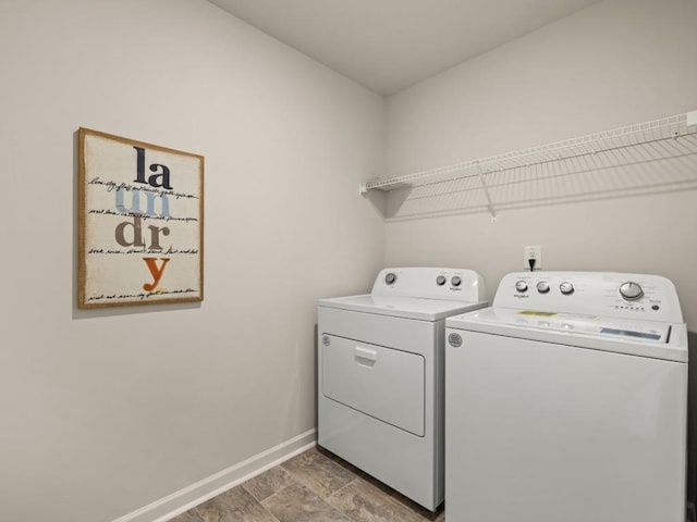 laundry area with laundry area, separate washer and dryer, and baseboards