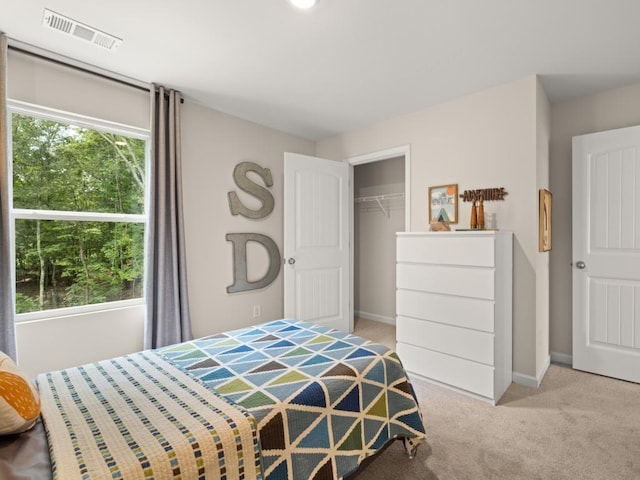 bedroom with light carpet, multiple windows, visible vents, and baseboards