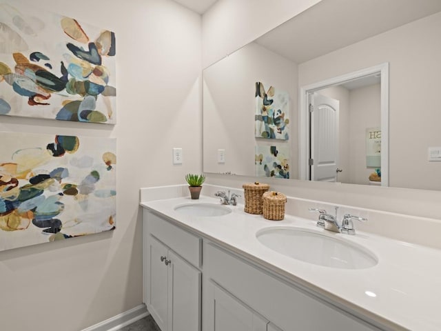 bathroom featuring a sink, baseboards, and double vanity