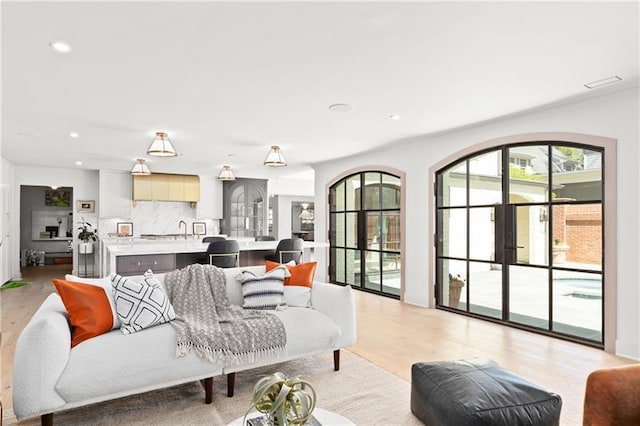 living area with recessed lighting, light wood-style flooring, and visible vents