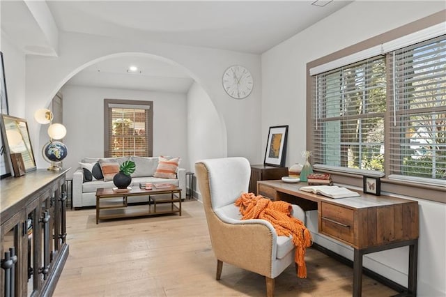 sitting room featuring recessed lighting, arched walkways, light wood finished floors, and a healthy amount of sunlight