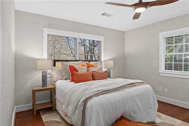 bedroom featuring visible vents, baseboards, and wood finished floors