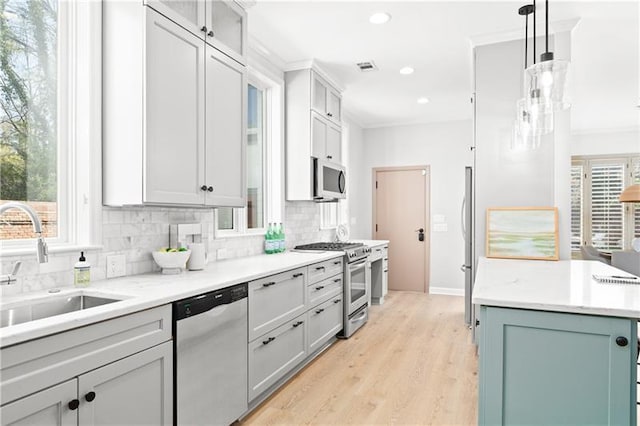 kitchen featuring light wood-type flooring, recessed lighting, plenty of natural light, tasteful backsplash, and appliances with stainless steel finishes
