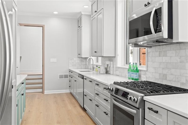 kitchen featuring a sink, light countertops, stainless steel appliances, and visible vents