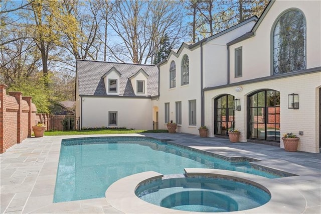 view of swimming pool featuring fence, a patio, and a pool with connected hot tub