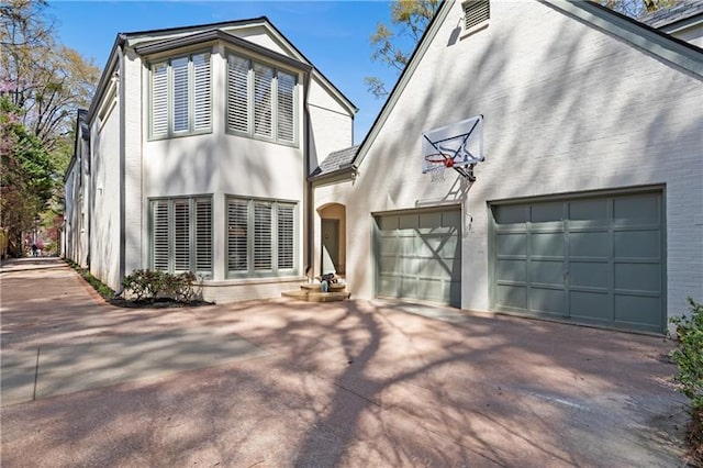 back of house featuring a garage, stucco siding, and concrete driveway