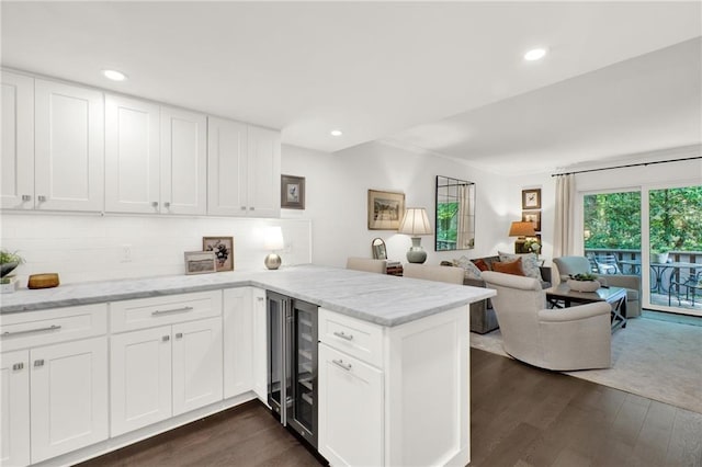 12 Ivy Rdg NE, Atlanta, GA 30342 - kitchen featuring a peninsula, dark wood-style floors, decorative backsplash, white cabinets, and light stone countertops
