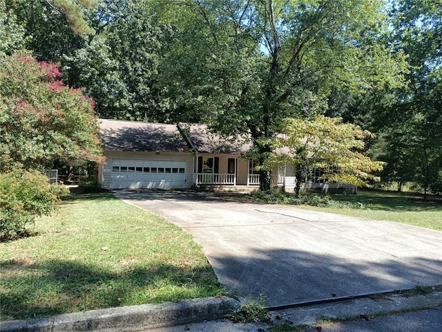 view of front of house with a porch, a front yard, and a garage