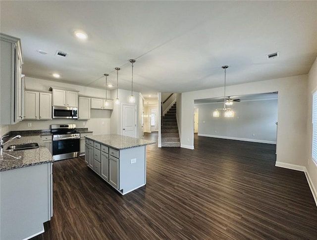 kitchen with a sink, appliances with stainless steel finishes, visible vents, and open floor plan