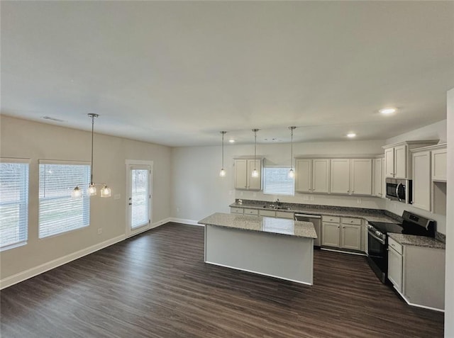 kitchen featuring dark wood-style flooring, a center island, stainless steel appliances, baseboards, and recessed lighting