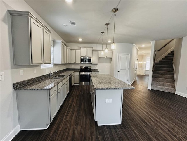 kitchen with a sink, dark stone countertops, stainless steel appliances, baseboards, and dark wood-style floors