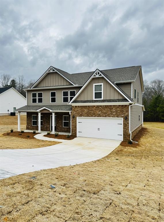 craftsman-style home with board and batten siding, a porch, roof with shingles, concrete driveway, and an attached garage