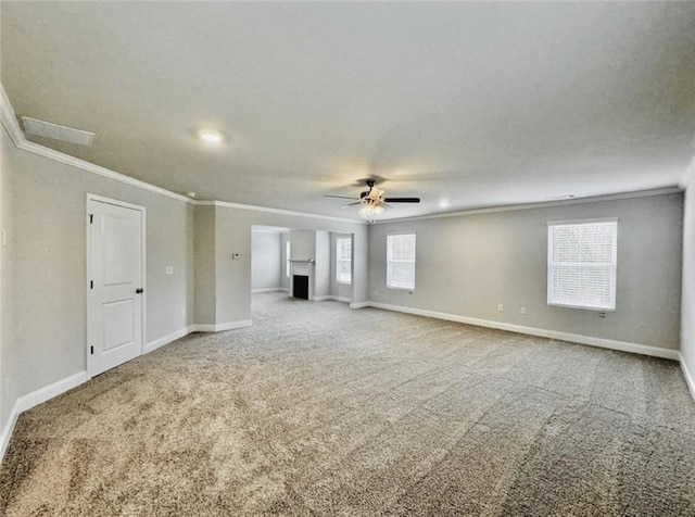 carpeted empty room with crown molding, baseboards, and ceiling fan