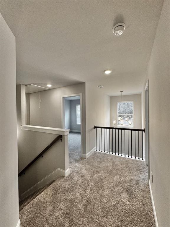 hallway featuring a wealth of natural light, carpet, attic access, and an upstairs landing