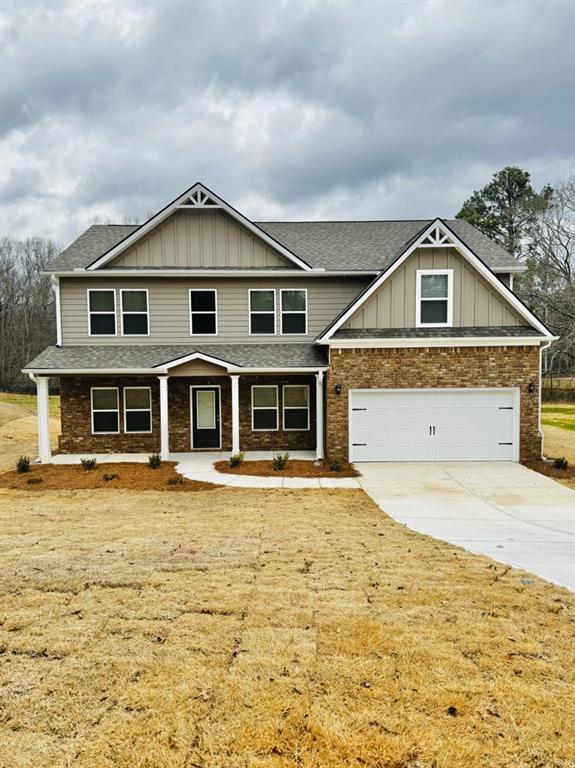 craftsman inspired home with roof with shingles, board and batten siding, and concrete driveway