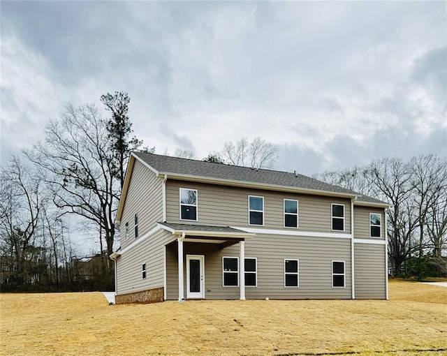 rear view of property featuring a lawn