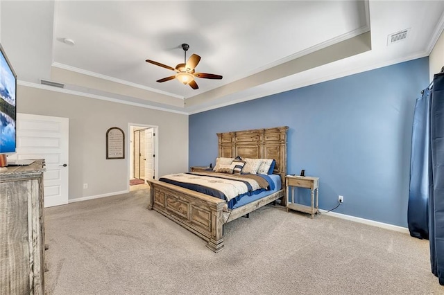 carpeted bedroom featuring a raised ceiling, connected bathroom, ceiling fan, and ornamental molding